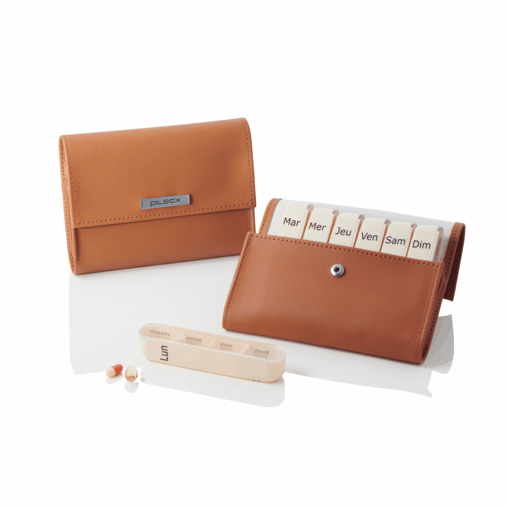 Pilulier Pilbox Liberty couleur camel fermé et ouvert avec compartiment pour un jour posé devant